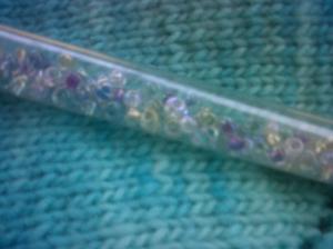 Beads on fabric of cowl.