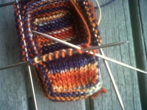 Creating the toe box: I'm knitting across the 10 stitches and the stitch from the side is already on my needle (the blue stitch to the far left) waiting to get knit together with the 10th stitch.